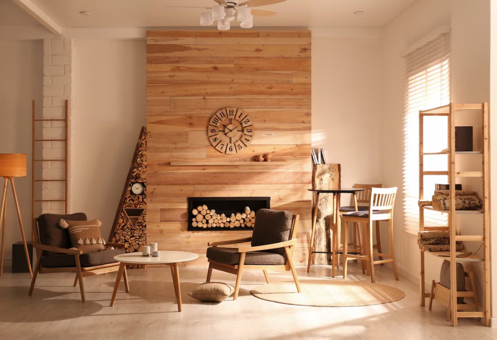 Sala de estar com elementos naturais, como a madeira, nos móveis e na decoração como exemplo de como aplicar o Hygge nos ambientes.