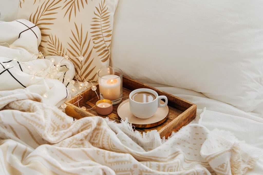 Café servido na cama, em um ambiente aconchegante, como exemplo das tendências Hygge, Lagom e Niksen.