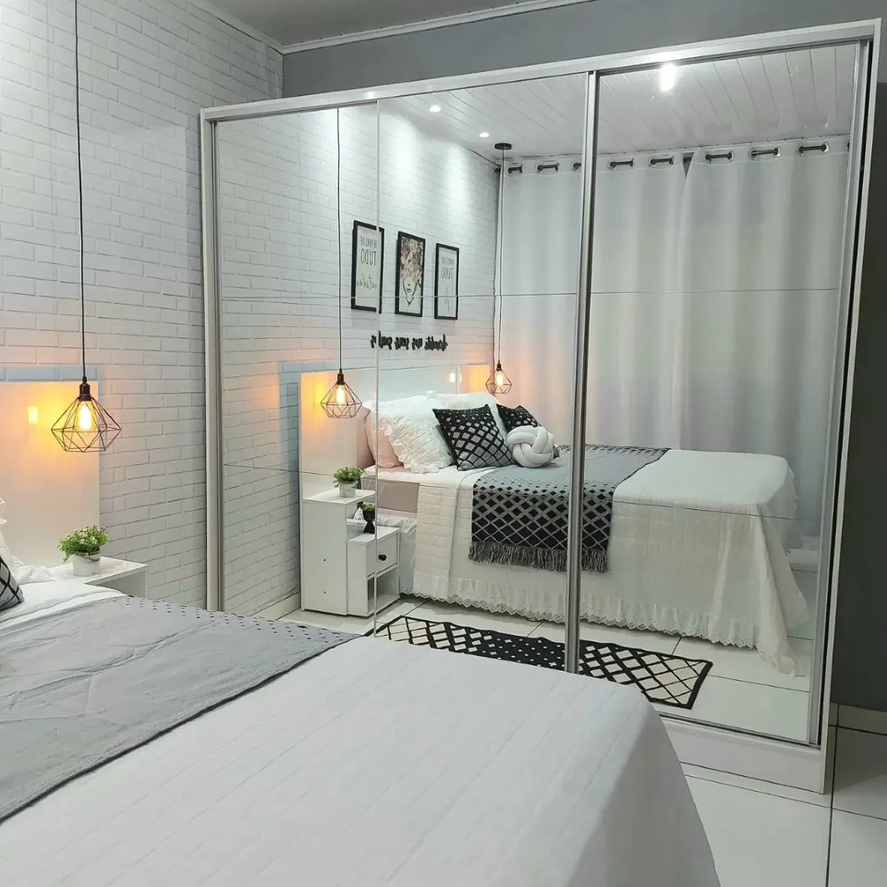 A imagem ilustra um quarto branco com guarda-roupas espelhado em uma casa organizada,