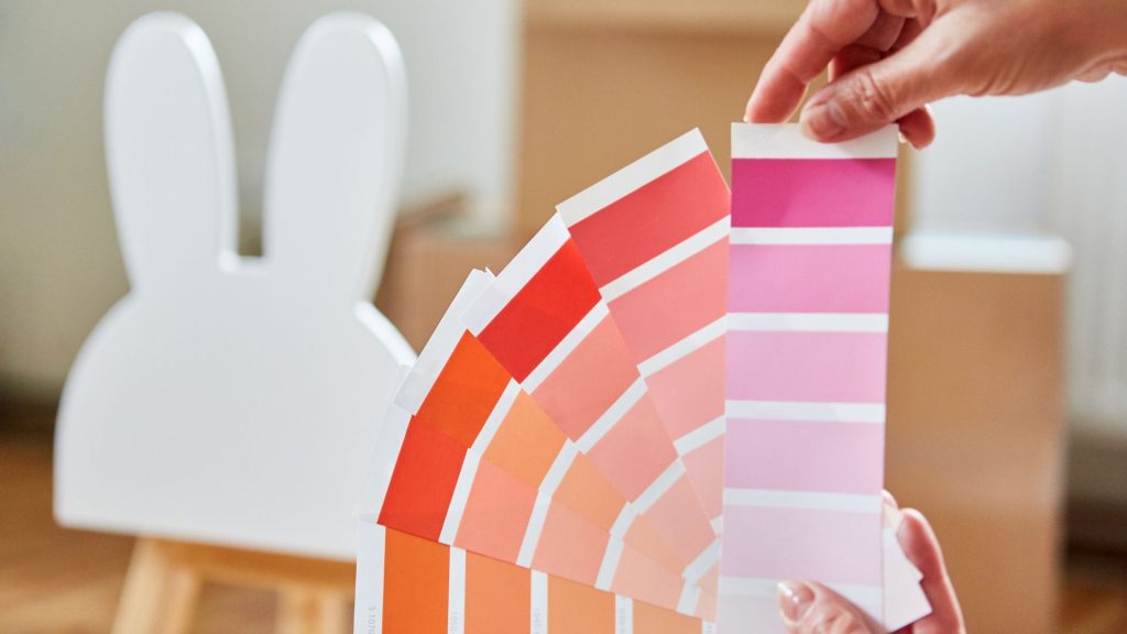 Pessoa usando uma amostra de cores em tons vermelhos e rosas como exemplo de como combinar cores.