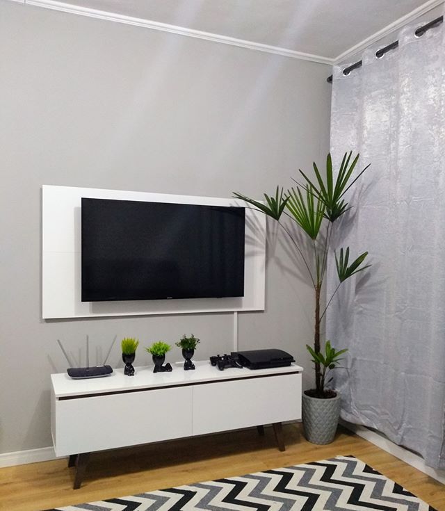 Sala de estar com paredes pintadas de cinza e rack e painel Madesa brancos.
