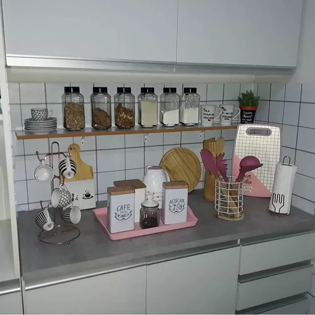 A imagem ilustra uma cozinha planejada decorada com porta-temperos e outros utensílios.