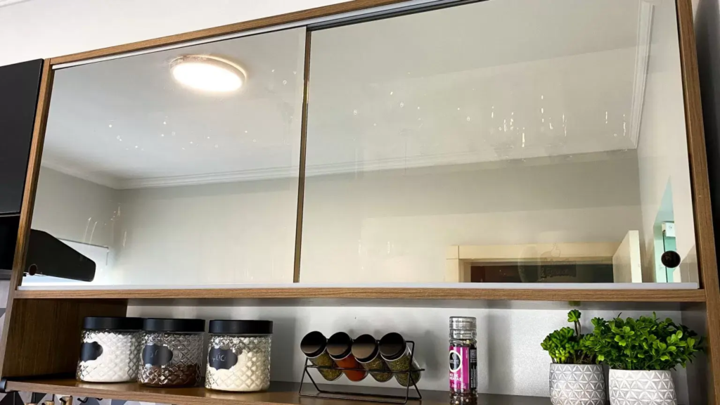 A imagem ilustra um armário de cozinha com portas espelhadas, dando amplitude ao estilo de cozinha.