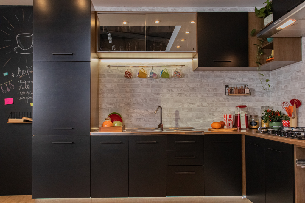A imagem ilustra um dos tipos de cozinha retro da Madesa, na cor preta, em uma cozinha ampla com muitos acessórios coloridos.