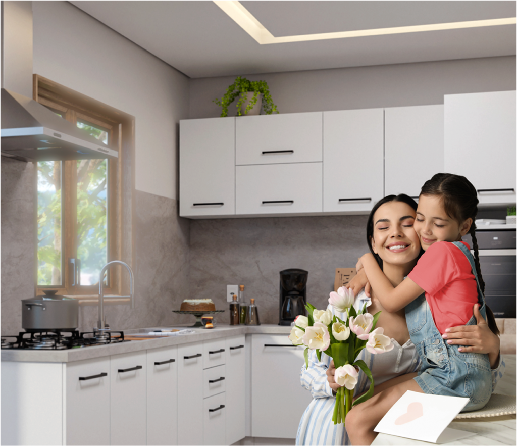 Texto alternativo: mãe sorridente segurando um buquê de tulipas brancas em uma cozinha moderna. Uma menina está abraçando a mãe, sorrindo. A cozinha tem armários brancos e uma janela que deixa entrar luz natural. Um cartão decorado está sobre a mesa.