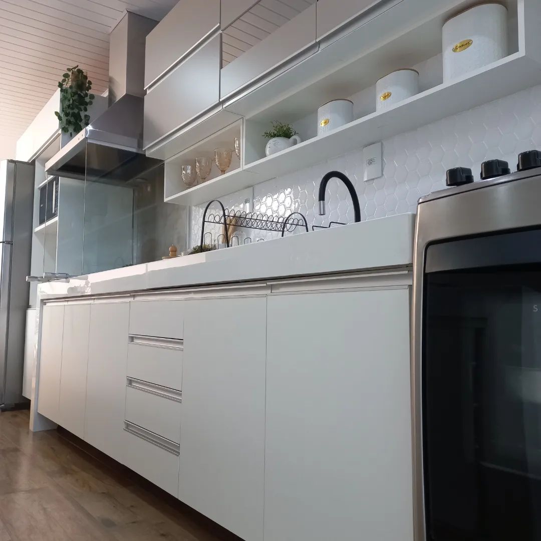 Imagem interna com foco em um armário de cozinha em MDF Madesa na cor branca.