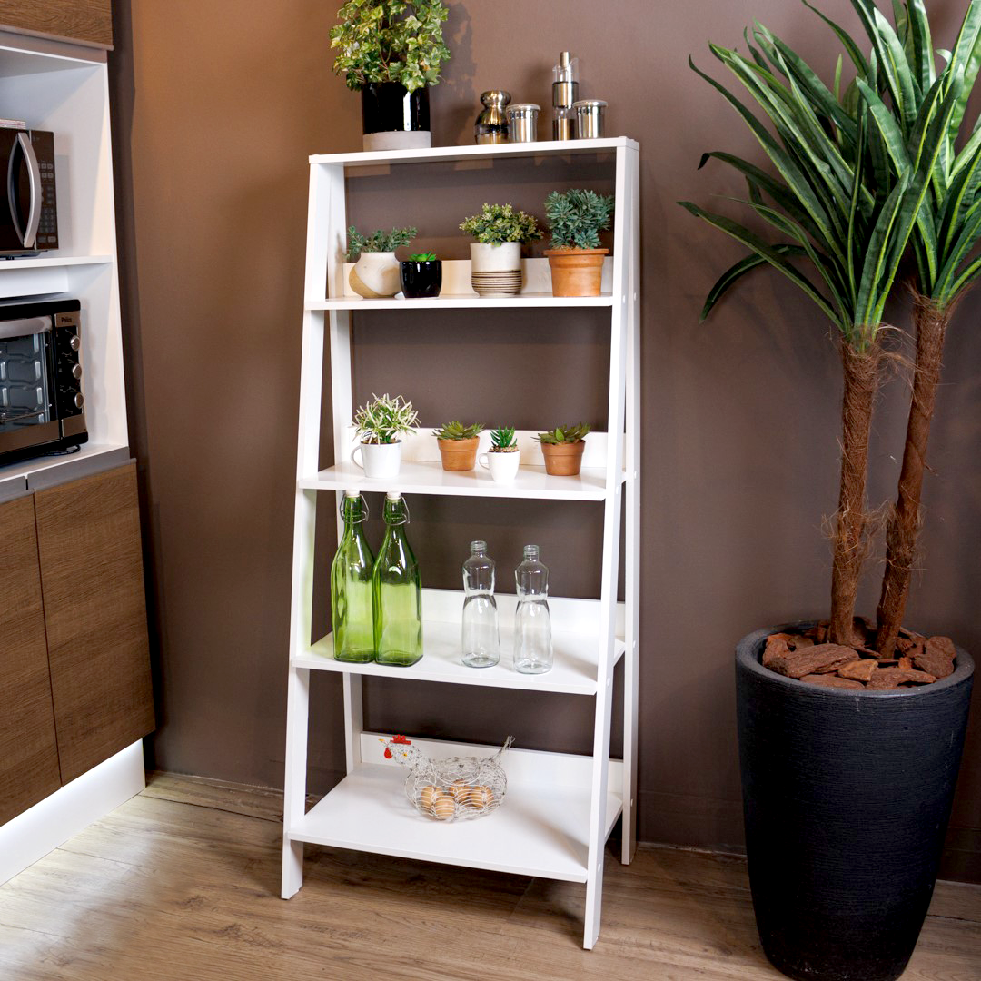 Imagem interna de um móvel de prateleiras estilo escada, com diferentes itens de decoração - incluso vaso de plantas