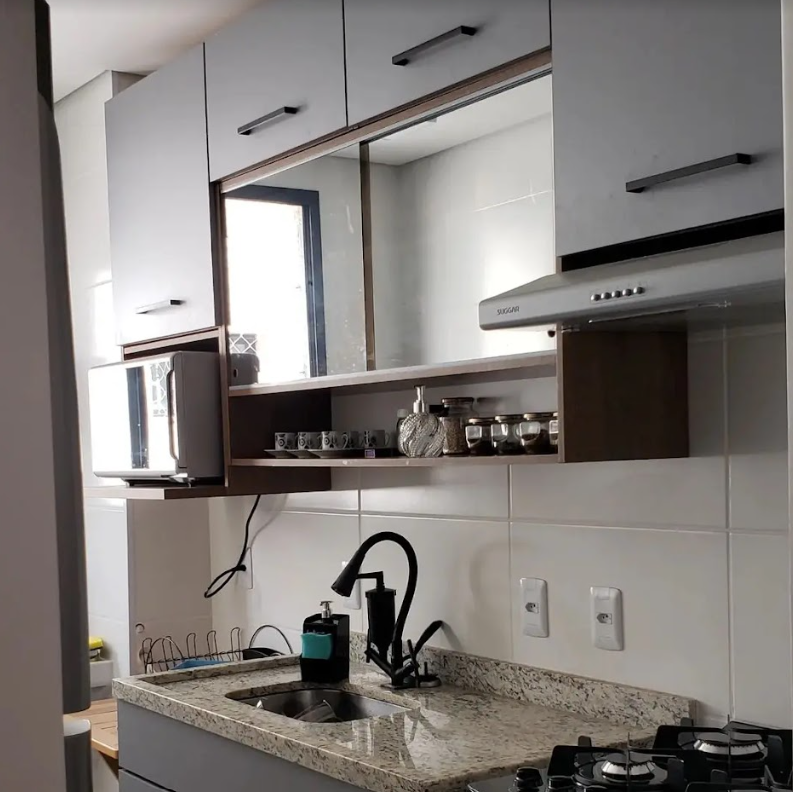 Imagem interna de uma cozinha, com foco nos armários superiores nas paredes. Eles são modulados em MDF Madesa, com detalhes espelhados. Logo abaixo, a pia e cooktop completam a imagem.