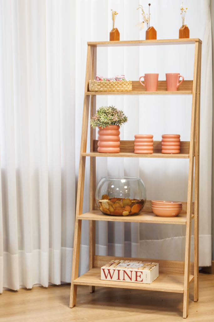 Estante escada Madesa, na cor amadeirado claro, decorada com vasos e cerâmicas.