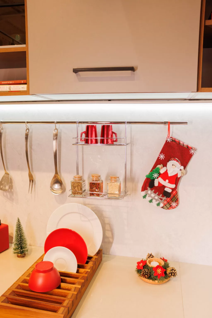 Bancada de cozinha Madesa vista de cima, decorada com meia de Natal, talheres e louças vermelhas e mini enfeites natalinos.