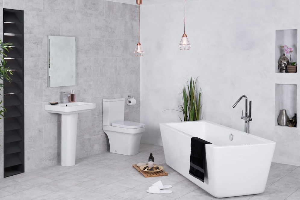 A imagem mostra um banheiro clean, com uma banheira, vaso e pia brancos.