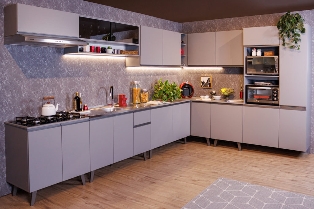 A imagem ilustra a linha nice de cozinha dos sonhos Madesa, com armários e bancadas cinza.