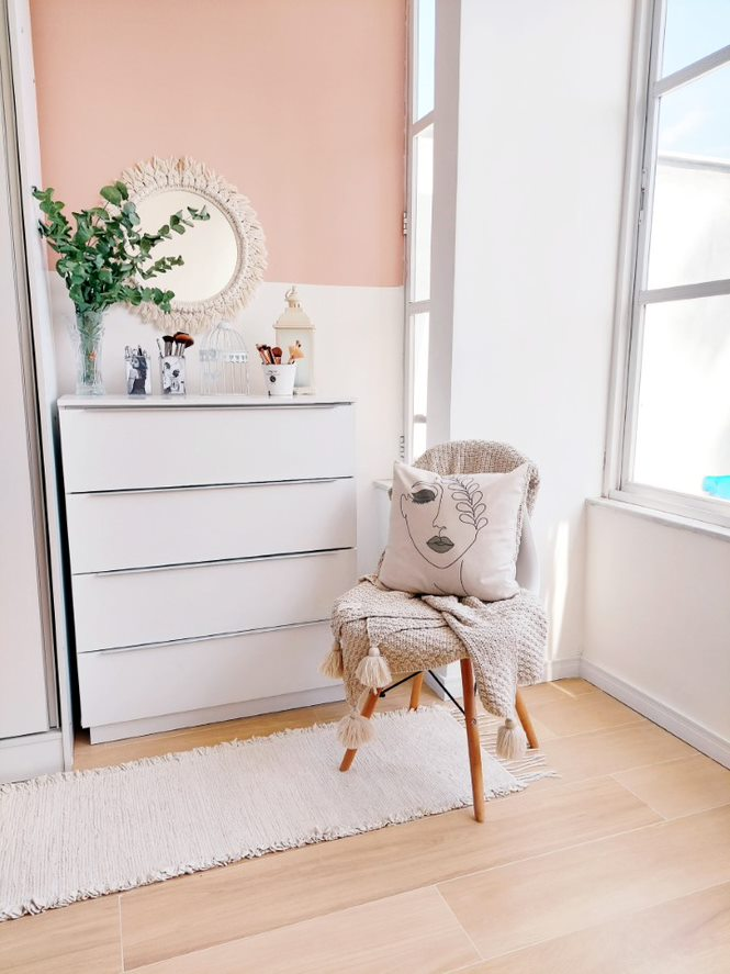 A imagem ilustra uma cômoda branca e uma cadeira à sua frente, simbolizando o quarto com closet pequeno. Em cima há um espelho e algumas plantas.