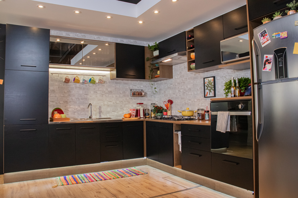 A imagem ilustra a linha agata de cozinha dos sonhos Madesa, com armários e bancadas na cor preta e puxadores metálicos.