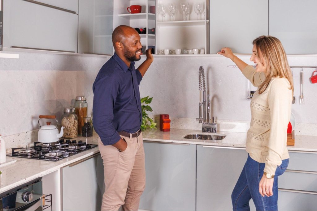 A imagem ilustra um casal em pé em uma cozinha planejada Madesa, simbolizando ideias para o dia dos namorados.