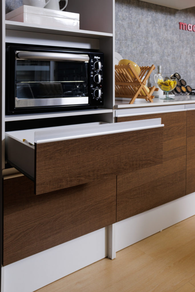 A imagem ilustra uma gaveta aberta de armário de cozinha gourmet pequena na cor marrom com detalhes brancos.