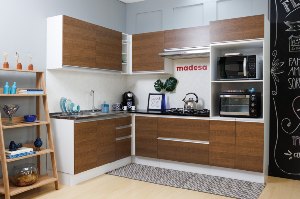 A imagem ilustra um dos modelos de cozinhas da Madesa, com acabamento em madeira rústica e pintura branca.