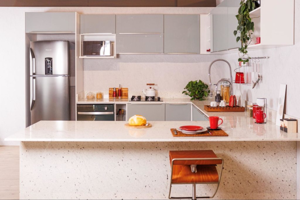 A imagem ilustra uma cozinha planejada Madesa com uma pedra para bancada de cozinha na cor branca.