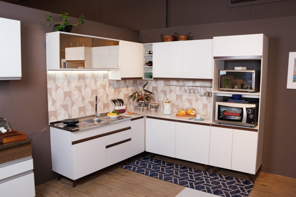 A imagem ilustra uma cozinha compacta planejada na cor branca em formato de L.