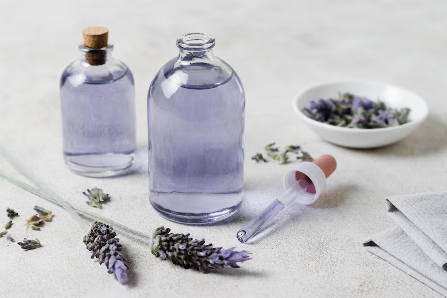 A imagem ilustra o que é aromaterapia através de 2 frascos de vidro com essência roxa de lavanda.