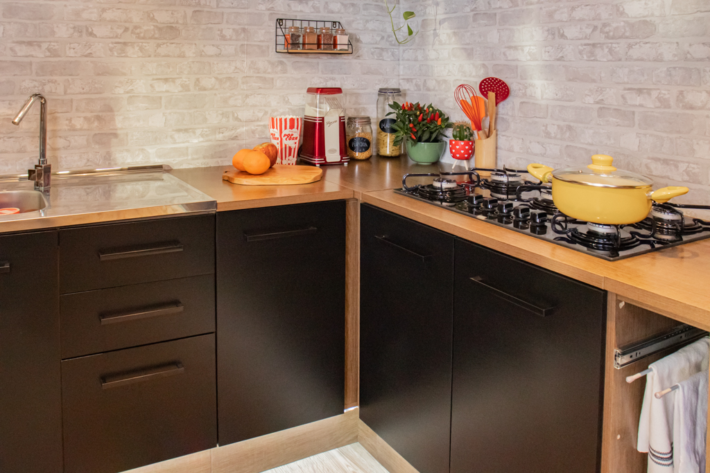Cozinha Agata Madesa, nas cores preto e rustic, decorada com utensílios de cozinha coloridos e eletrodomésticos.