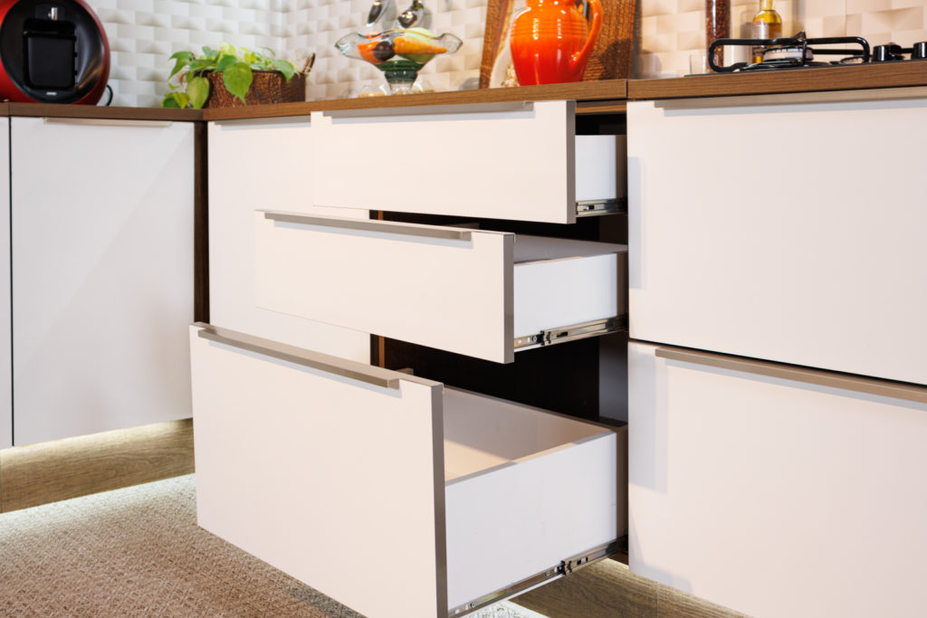 A imagem ilustra os armários da cozinha planejada Lux Rustic na cor branca, com as três gavetas abertas.