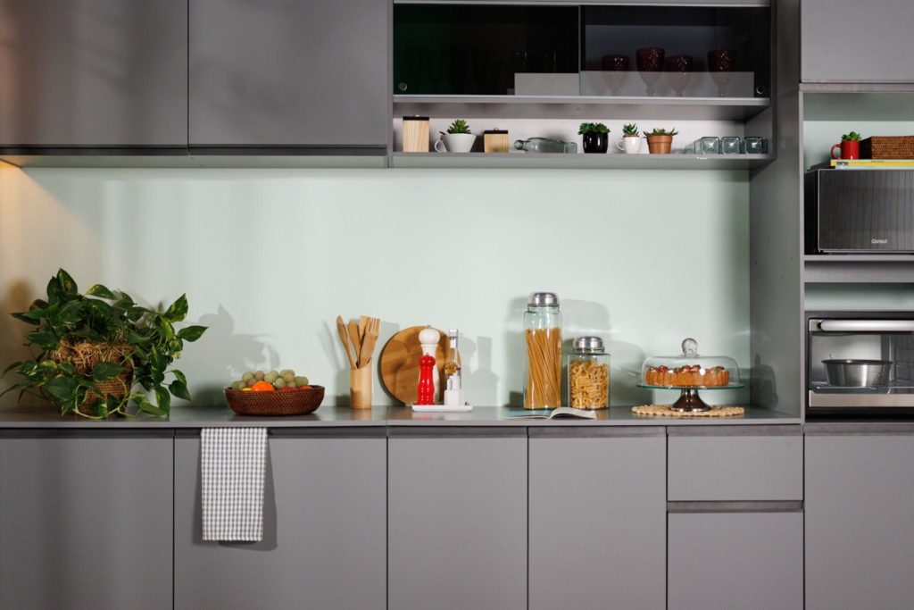 Foto fechada do balcão da cozinha Nice, na cor cinza, decorado com utensílios de cozinha.