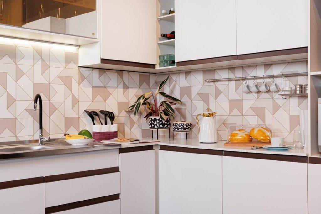 Cozinha de canto Reims, na cor branca, decorada com utensílios de cozinha variados.