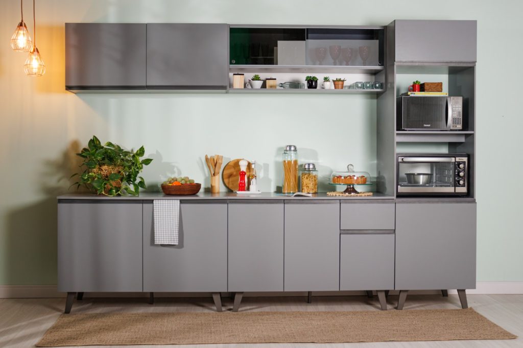 Cozinha compacta da linha Nice, na cor cinza, decorada com utensílios e eletrodomésticos.