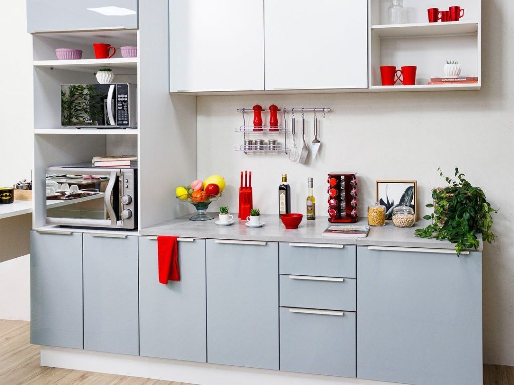 Imagem com foco nos armários de cozinha da linha Agata, na cor preta. Em cima dos móveis, há utensílios de decoração.