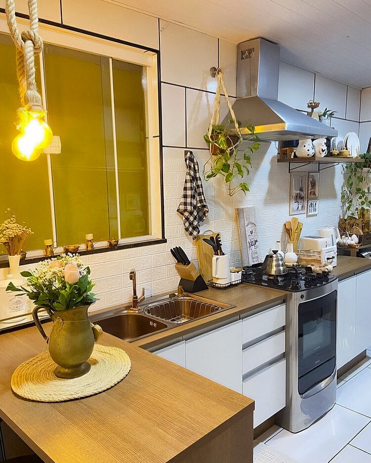 Cozinha Madesa, nas cores rustic e branco, decorada com plantas, utensílios e louças.