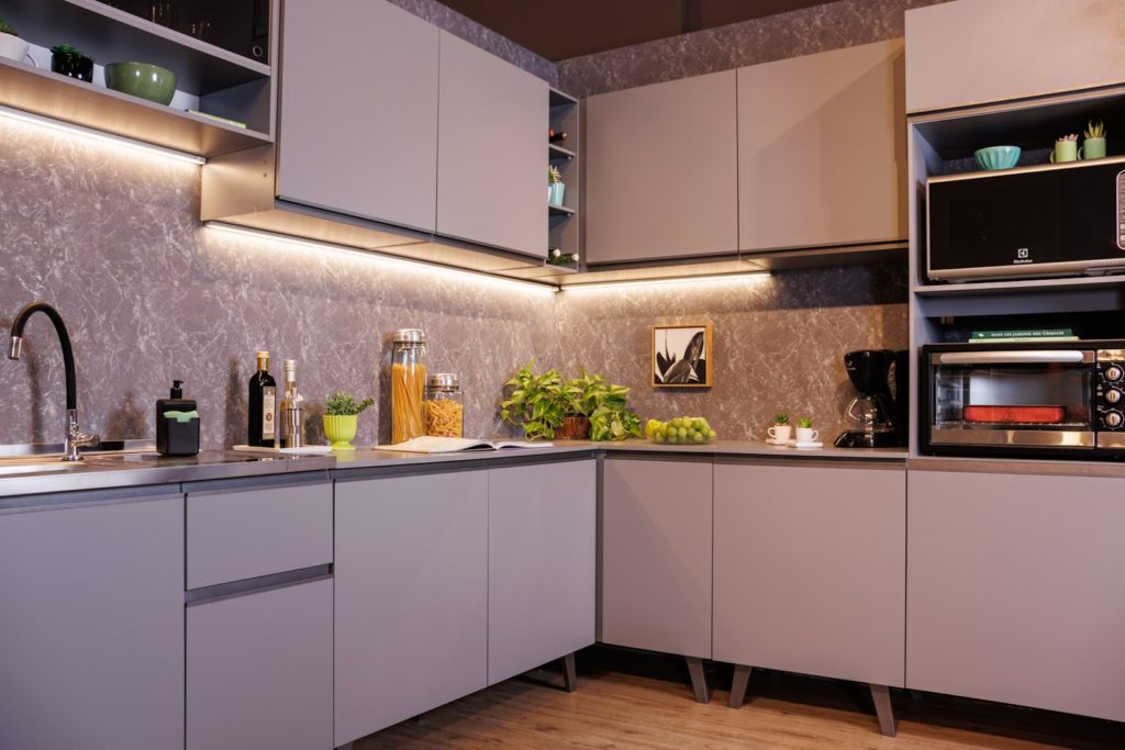Cozinha Nice, na cor cinza, decorada com utensílios de cozinha e eletrodomésticos.