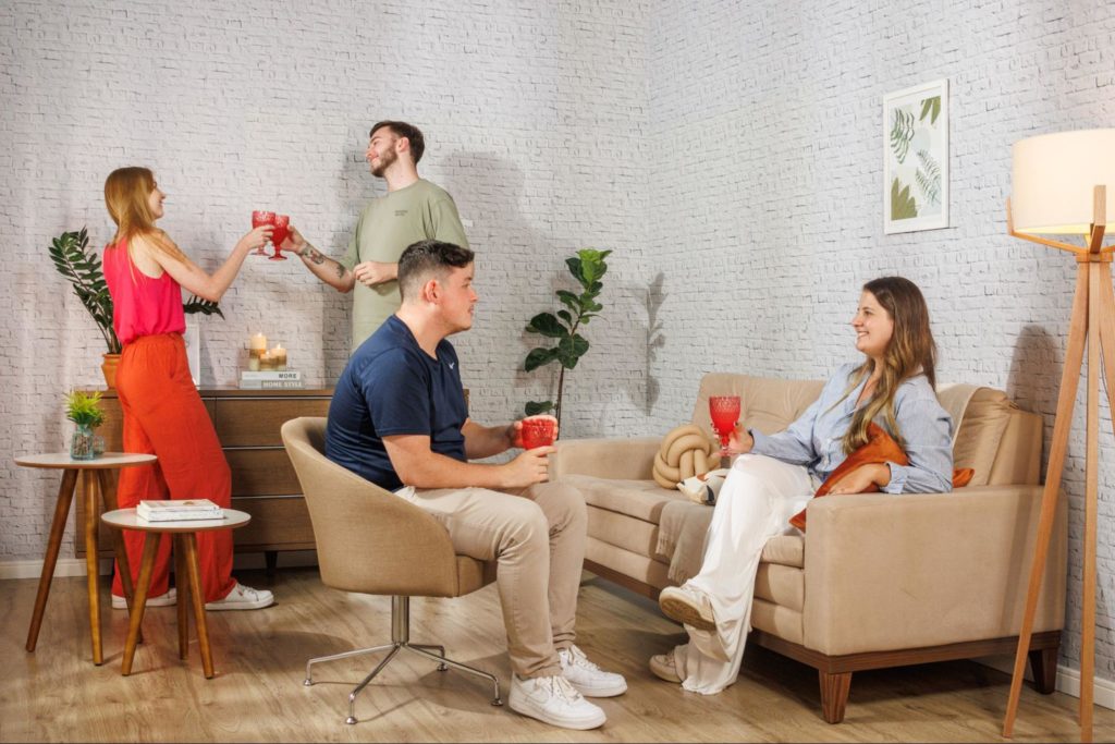 Família unida, conversando numa sala de estar Madesa, com móveis em cores amadeiradas e crema.