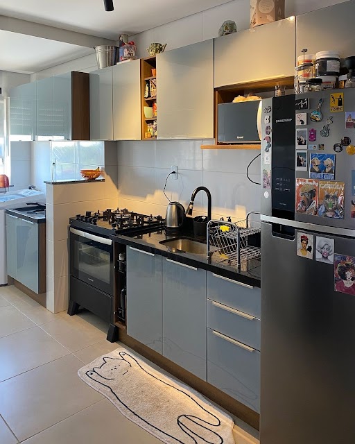 Cozinha linear com armários Madesa na cor cinza claro e eletrodomésticos e demais utensílios nas cores preto e cinza.