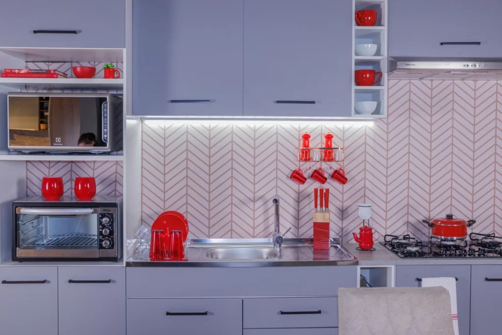 Cozinha Lux Madesa, decorada com utensílios e eletrodomésticos na cor vermelha, contrastando com os armários cinza.
