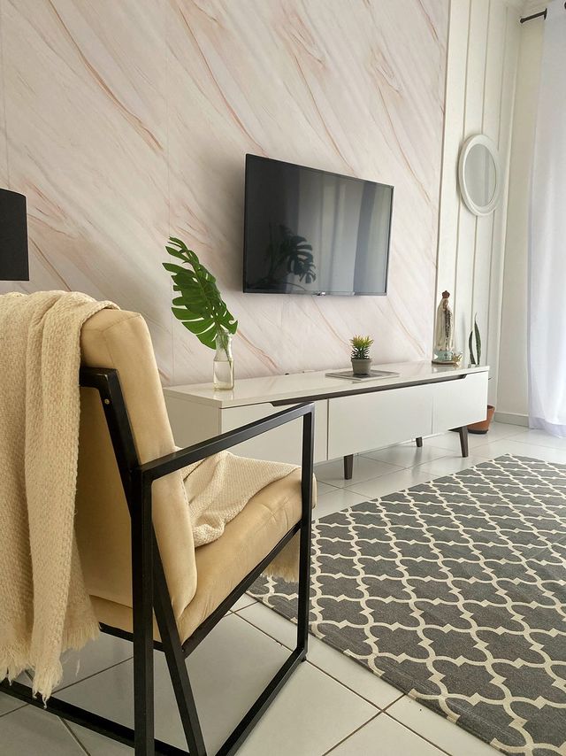 Sala de estar decorada com um tapete cinza estampado e, à frente, um rack Madesa na cor branca.