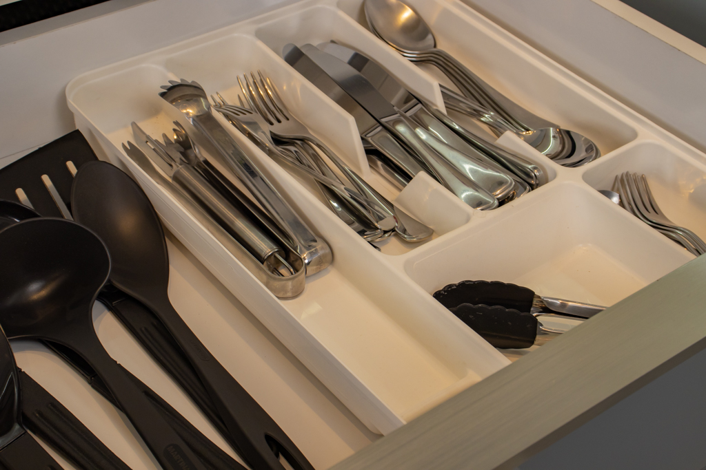 talheres e utensílios dispostos em divisórias de cozinha