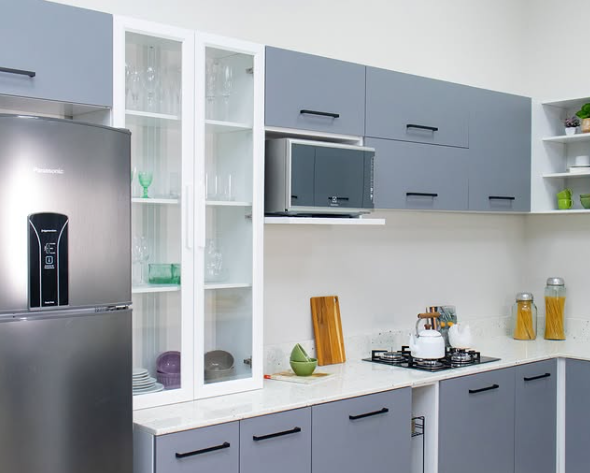 Cozinha com armários cinzas, cristaleira branca, geladeira de inox, micro-ondas e um cooktop instalado na bancada.