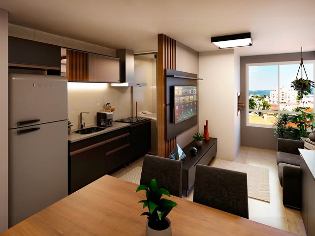 Sala de estar e cozinha integradas, com uma televisão grande na parede, um sofá ao lado da janela com vista para prédios e árvores. Uma mesa de jantar com uma planta no centro, uma geladeira branca ao lado da cozinha, armários escuros na cozinha, uma luminária de teto retangular e uma planta pendurada na varanda.