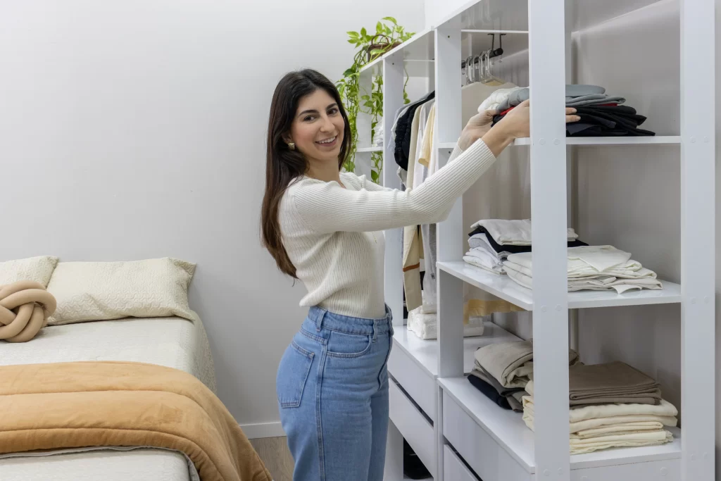 Moça organizando closet Madesa com objetos