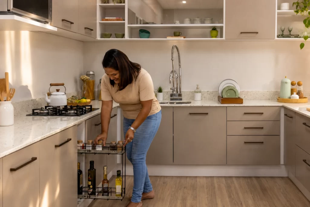 Mulher usando um módulo aramado extraível em cozinha planejada crema linha Agata da Madesa em apartamento.