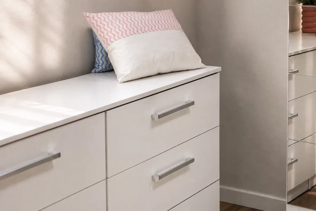 Cômoda Madesa branca com tampo de apoio e gavetas para organizar roupas no quarto.
