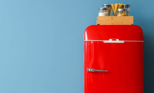 Red fridge and box with food near blue wall