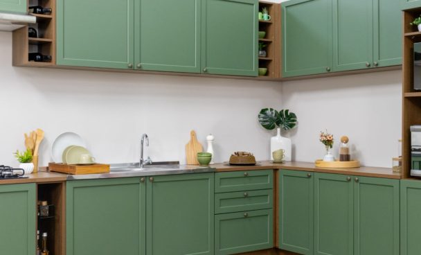 Armário de cozinha da linha Vik. Cozinha com portas verde floresta com caixaria em amadeirado rústico escuro em frente a uma paree clara.