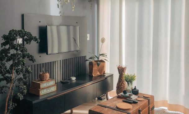 Sala de estar rústica com baú antigo e móveis pretos da Madesa.