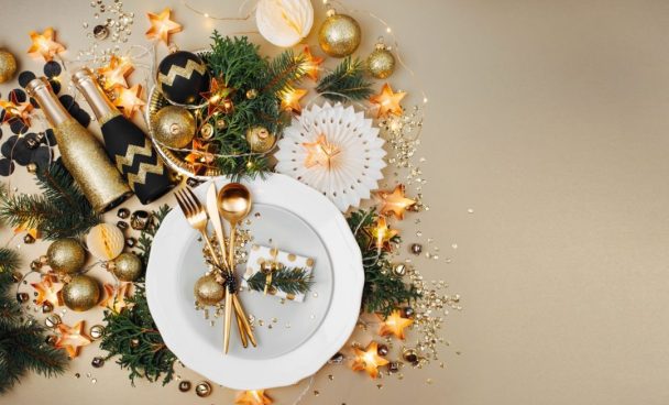 Mesa de ano novo decorada com enfeites dourados.