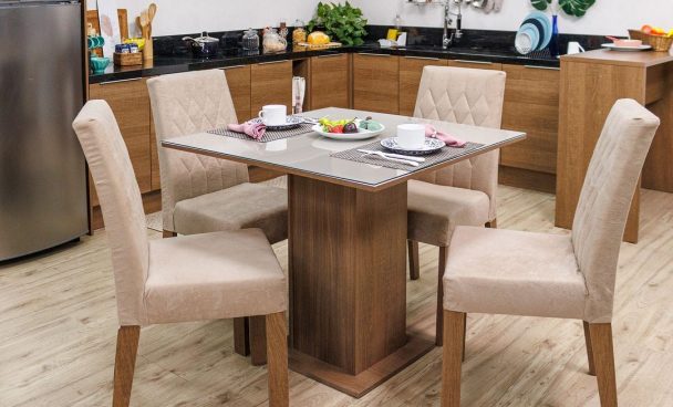 Conjunto de sala de jantar Anaju Madesa nas cores crema e rustic, com a mesa posta e decorada. Ao fundo, cozinha Madesa decorada com utensílios e eletrodomésticos.