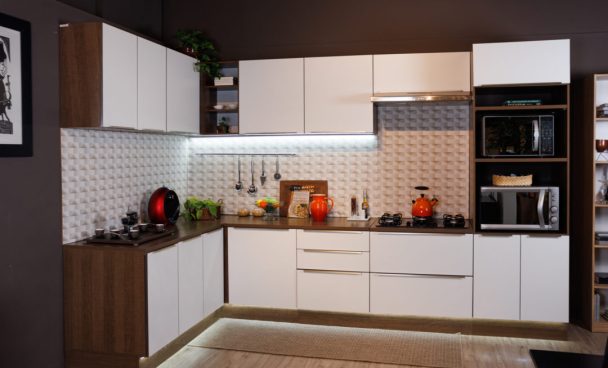 A imagem ilustra uma cozinha branca com madeira Madesa com detalhes em decoração e iluminação.