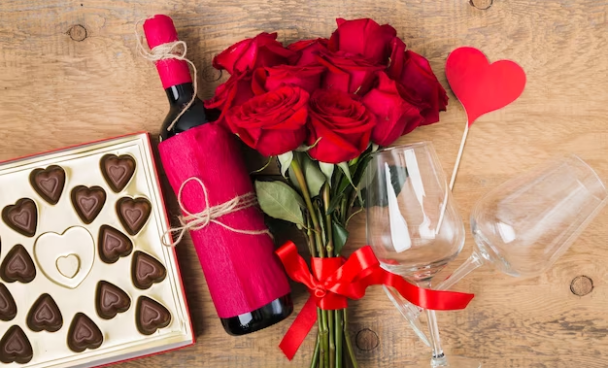 A imagem ilustra um buquê de rosas vermelhas, uma garrafa de vinho e uma caixa de chocolates como ideias para o dia dos namorados.