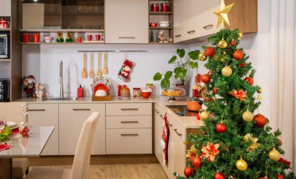Cozinha Madesa, decorada com diversos utensílios natalinos nas cores verde e vermelho. À direita, uma árvore de Natal ao lado dos armários de cozinha.
